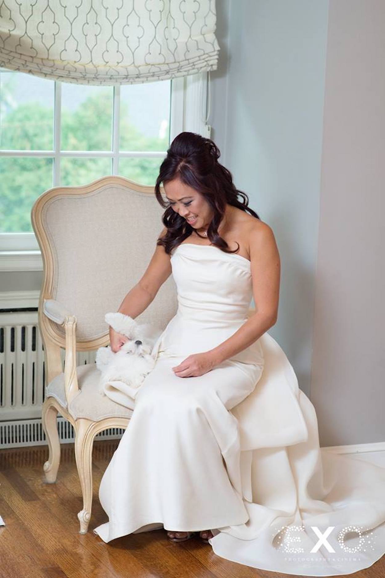 bride wearing kleinfeld bridal designed by le spode di gio sitting with dog