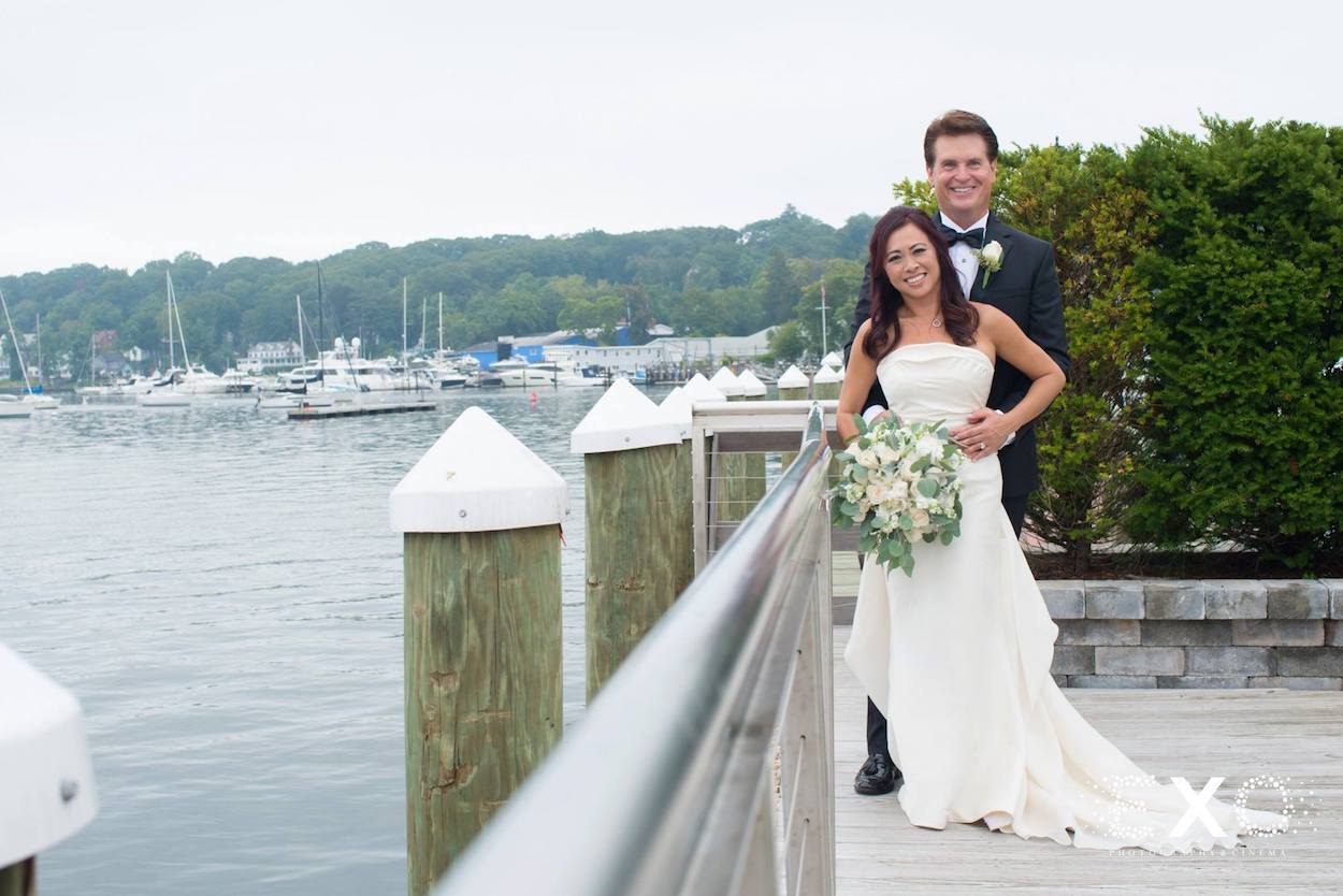 bride and groom on dock by water