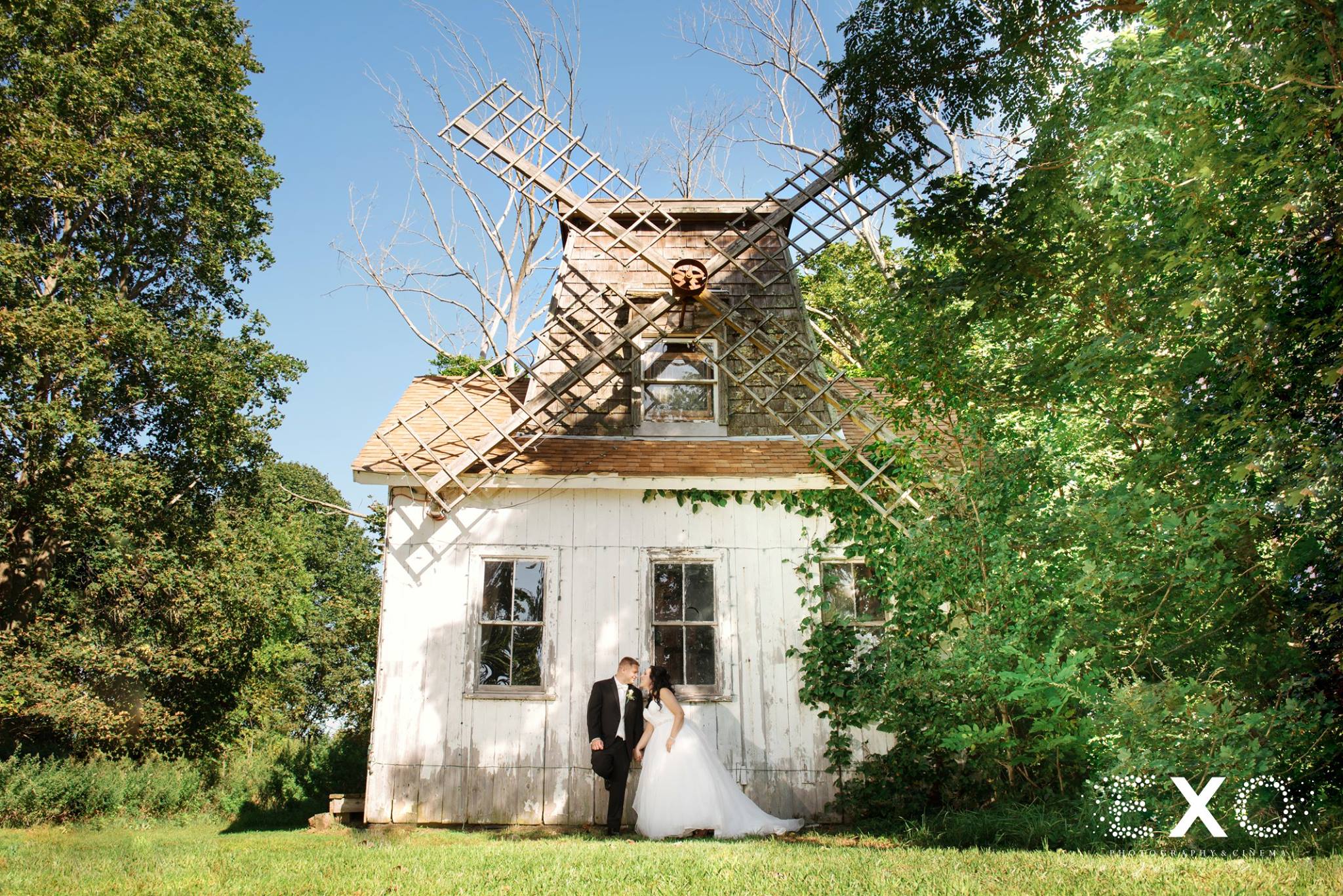 bride and groom under old windmill at Giorgios