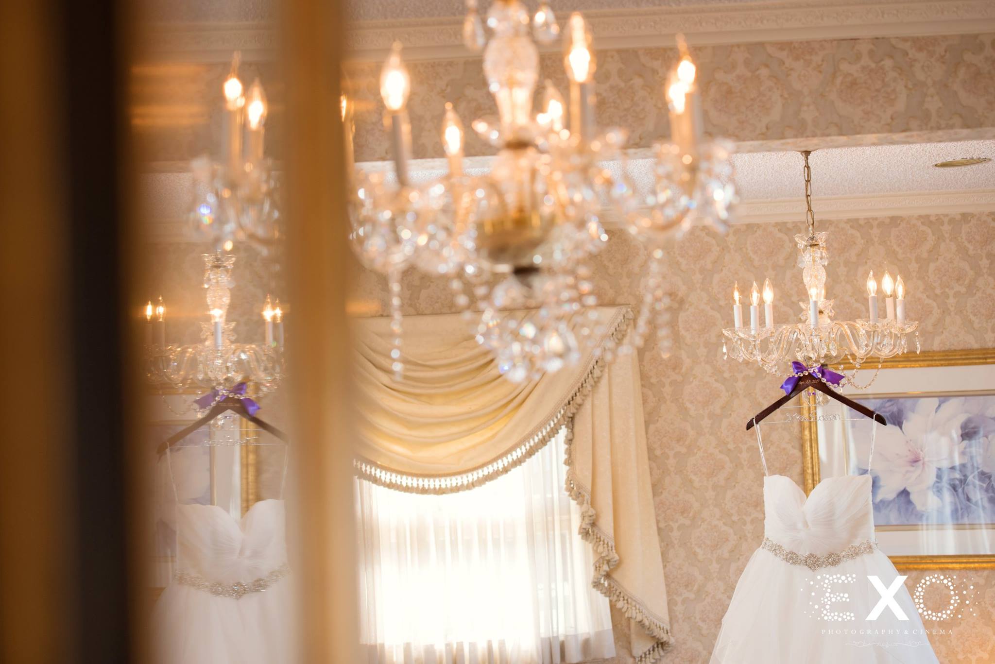 bridal gown hanging from chandelier 
