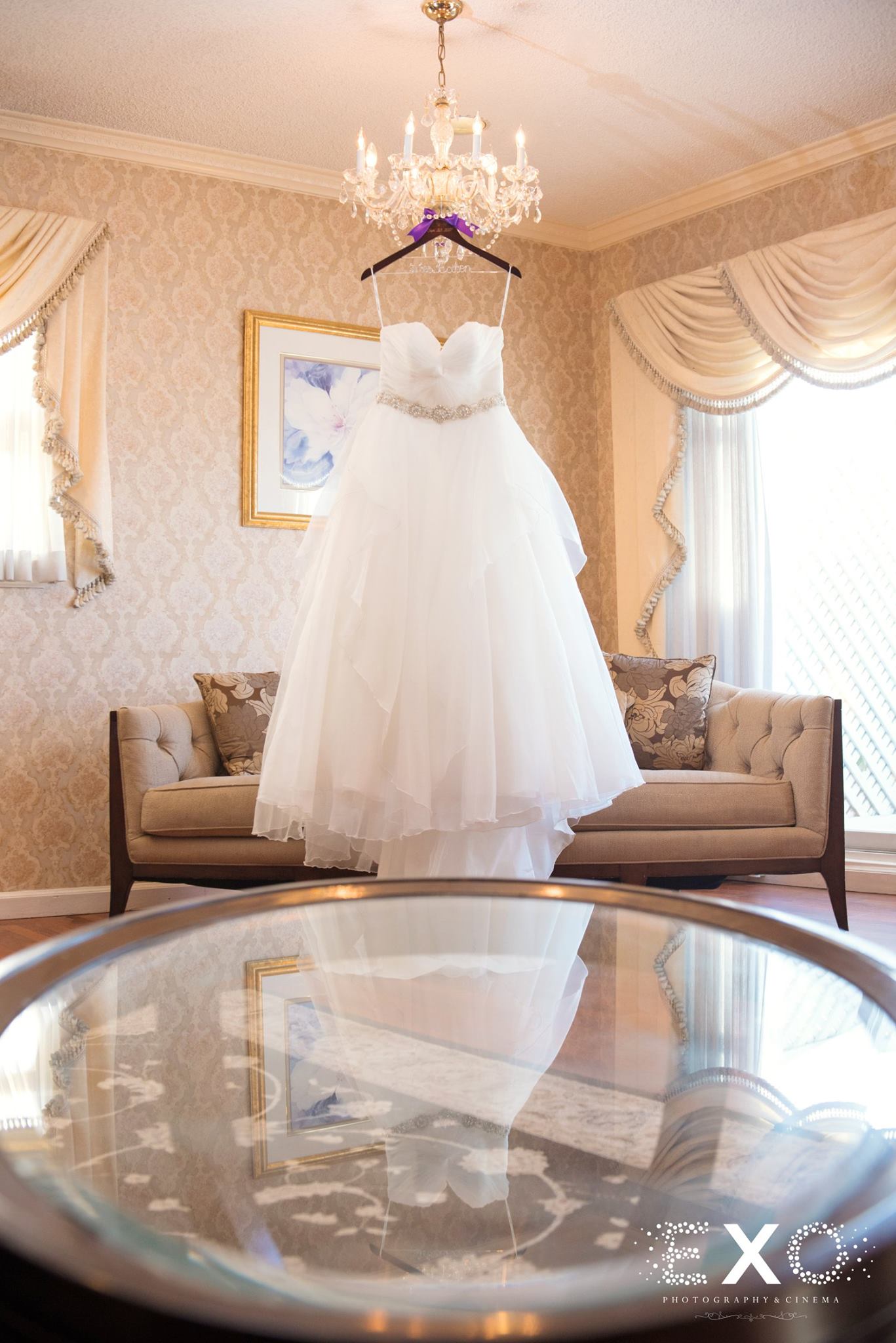 bridal gown from burton bridals designed by stella york hanging from chandelier 