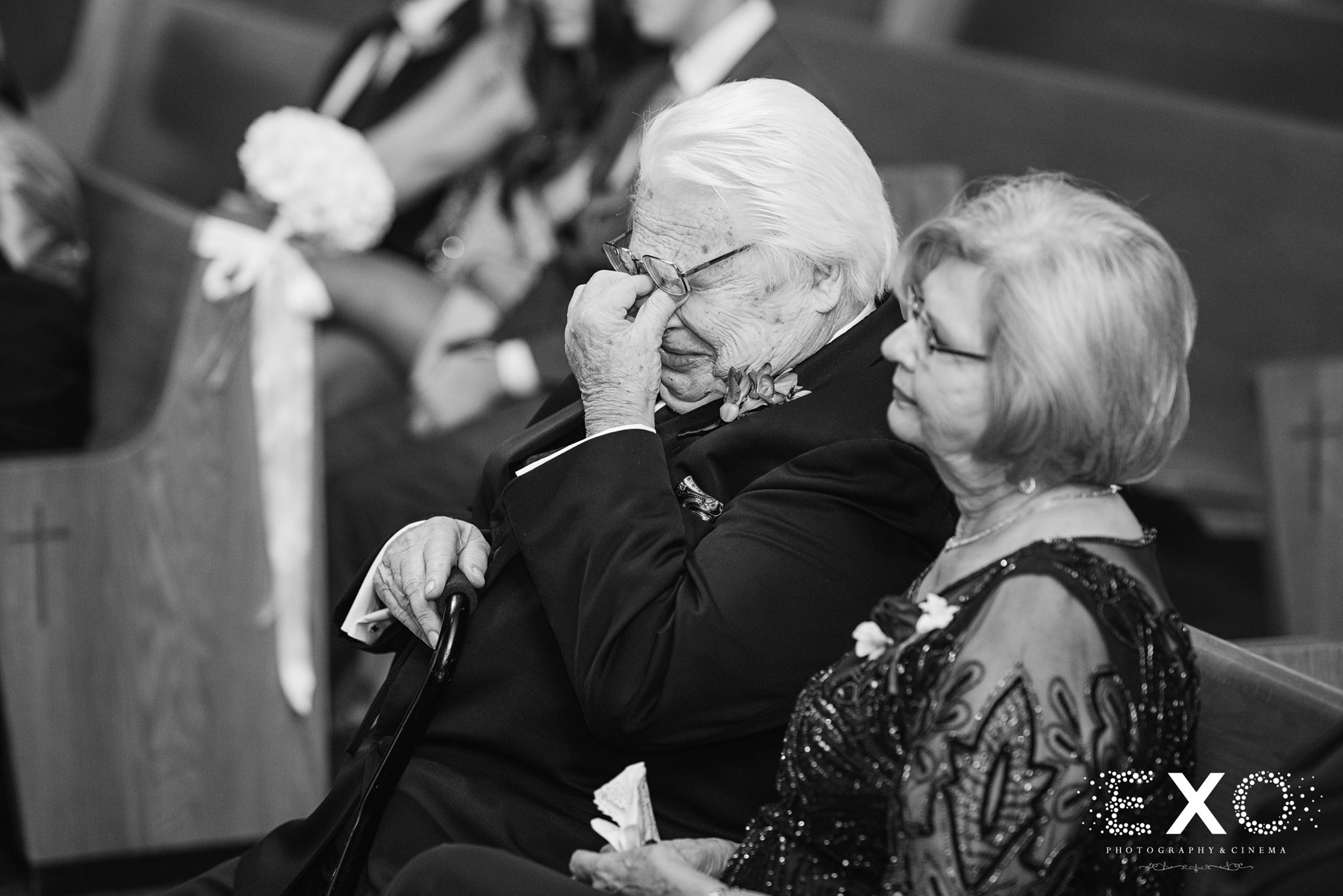 black and white photo of wedding guests crying during ceremony
