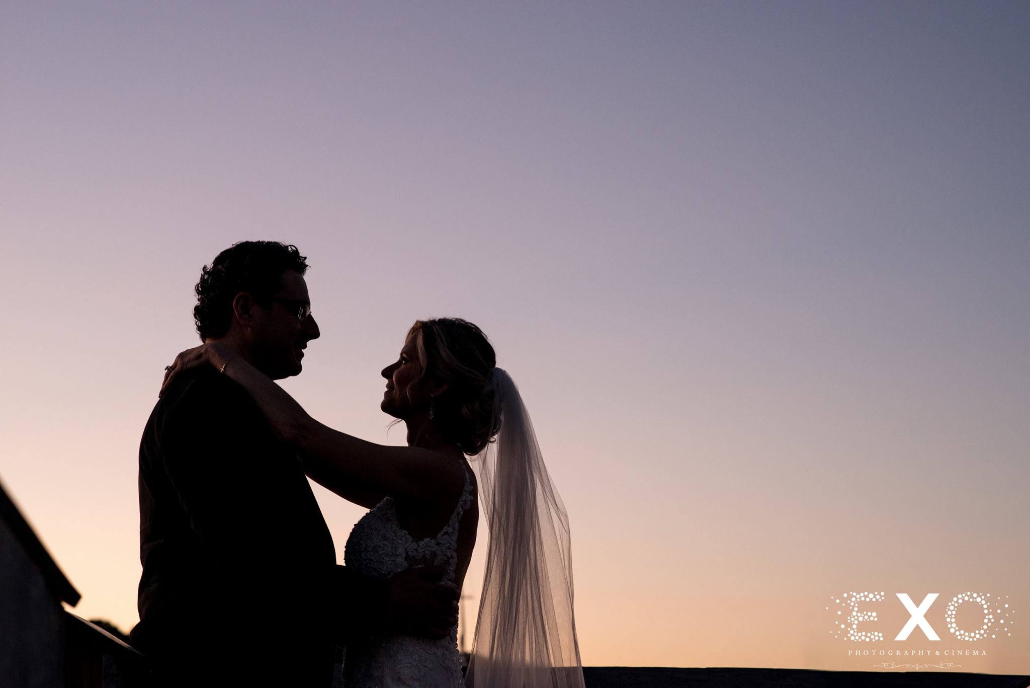 silhouette shot of bride and groom at sunset