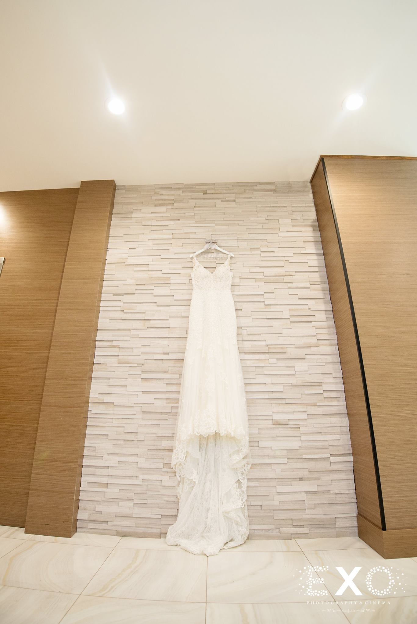 bride's martina liana gown hanging on wall