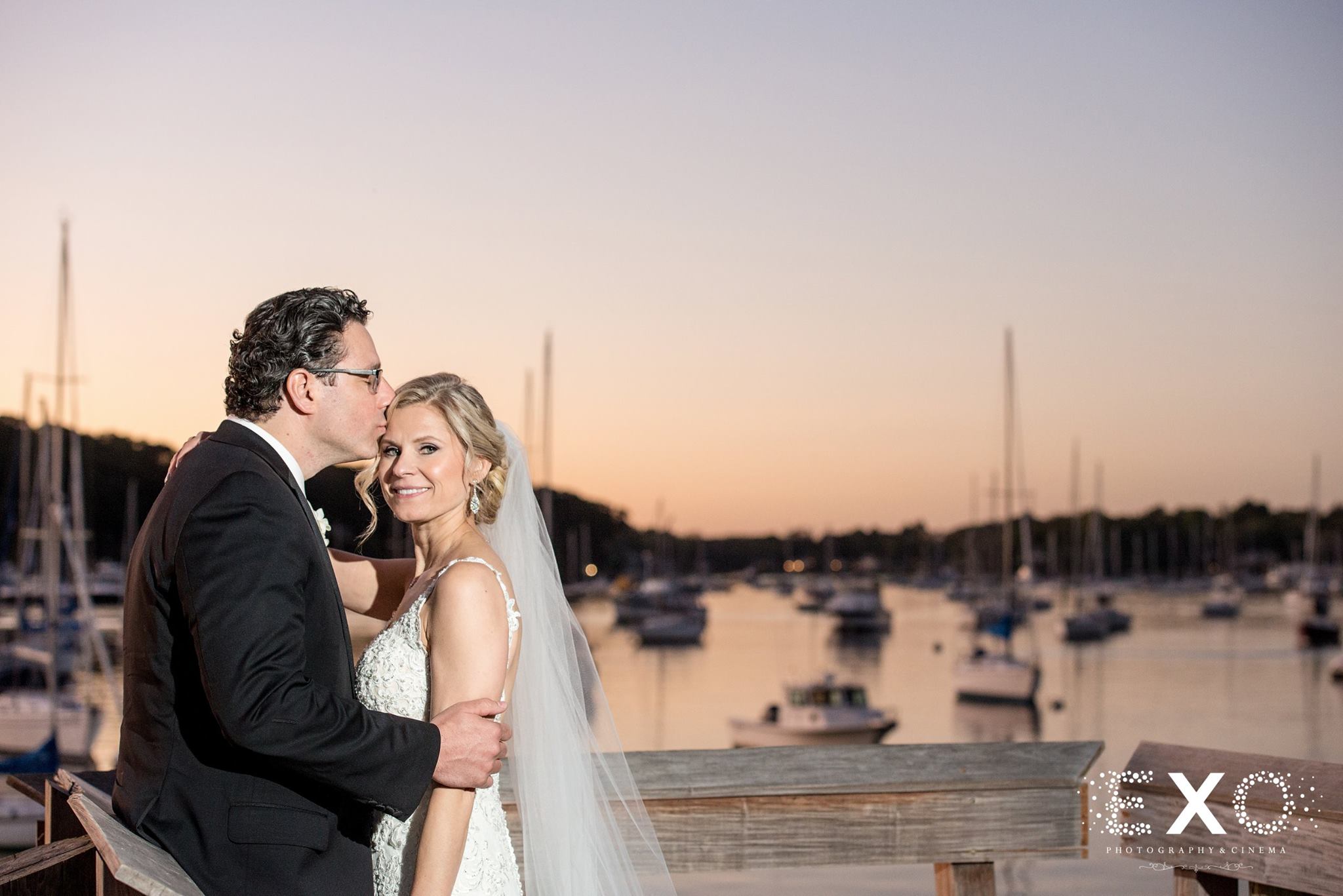 bride and groom on dock at sunset 