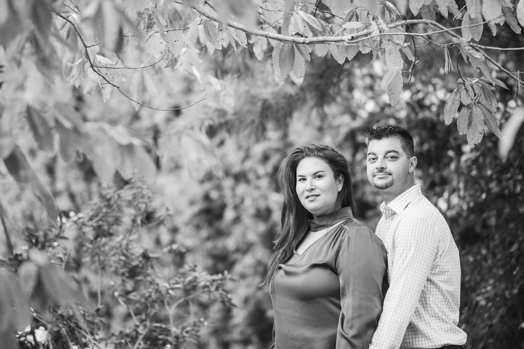 black and white image of couple by trees at Planting Fields Arboretum