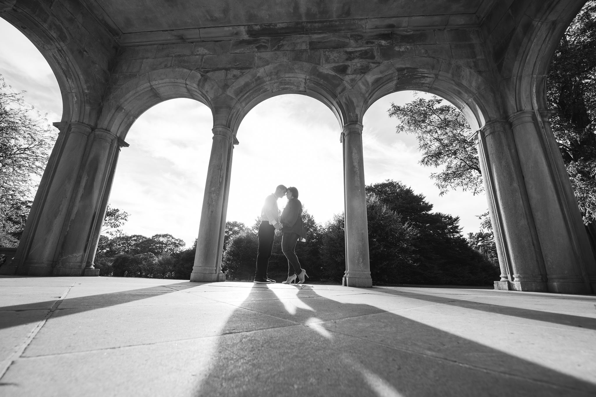 black and white image of couple under arched doorways at Planting Fields Arboretum