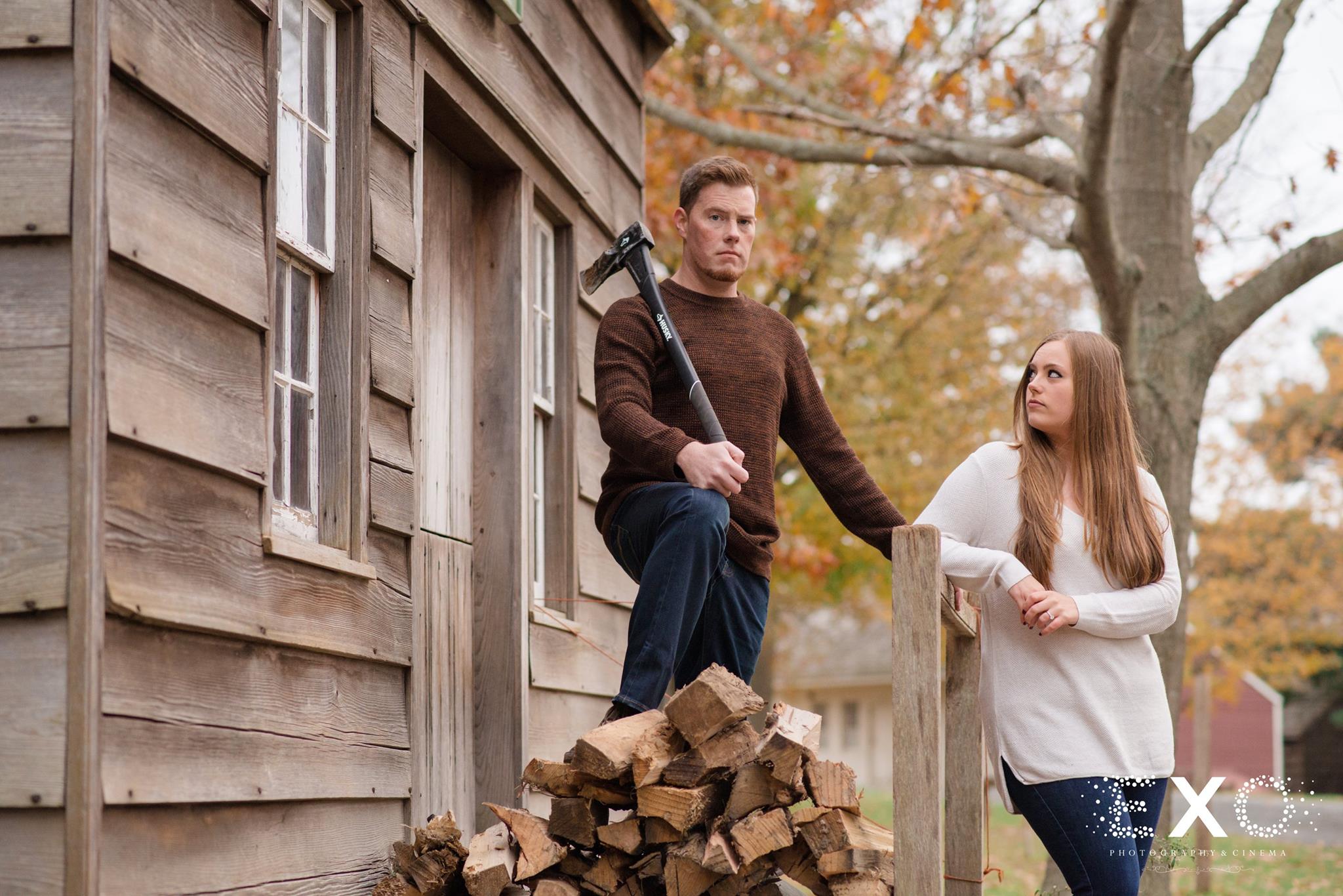 fun image of couple at Old Bethpage Village Restoration with axe and wood
