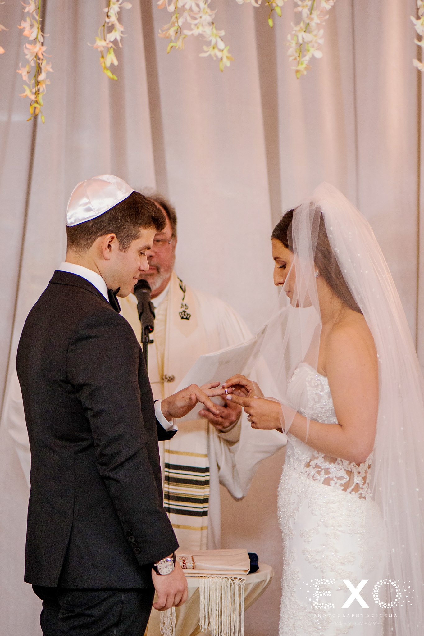 bride and groom exchanging rings from klim jewelry with cantor neil a. berris