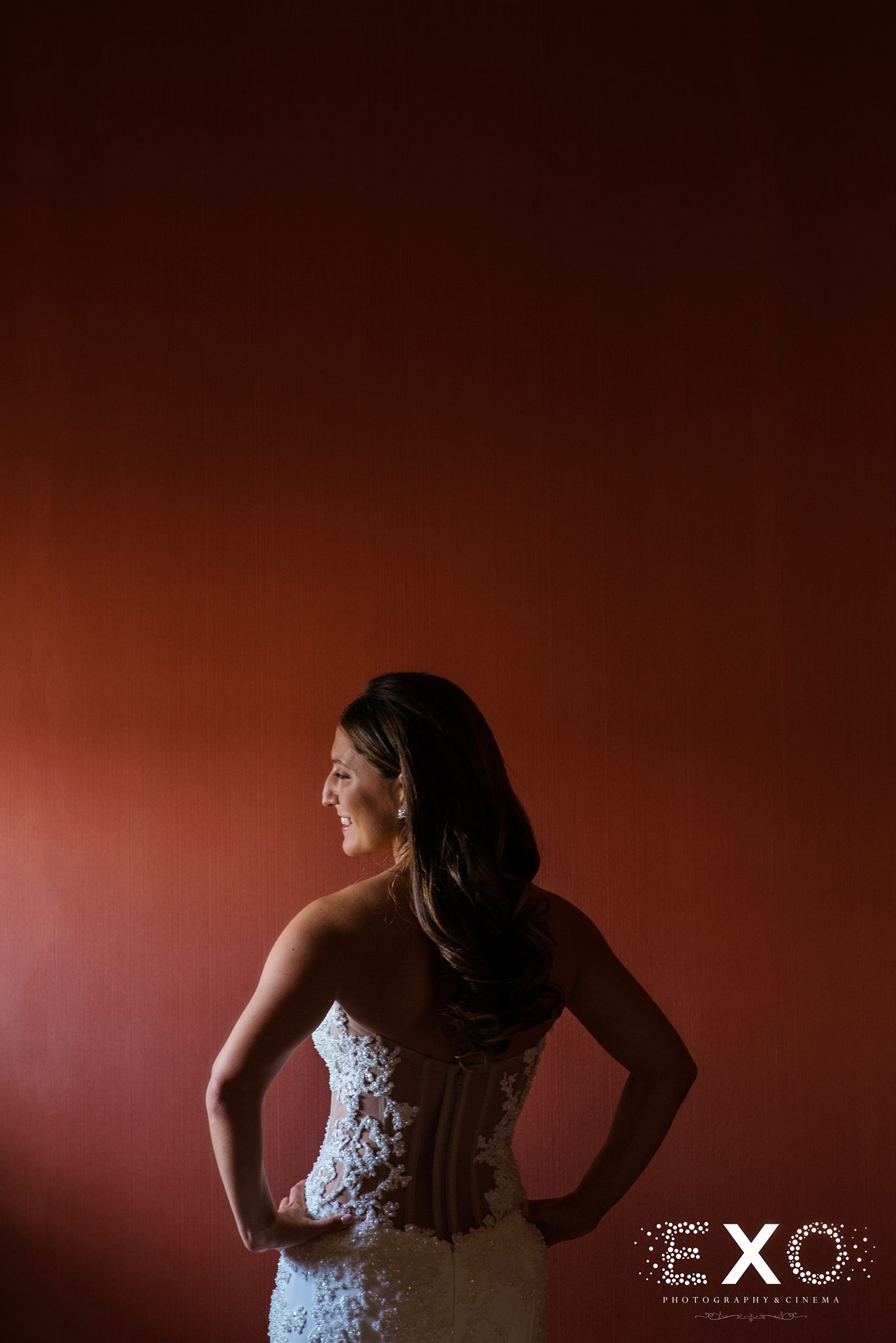 dramatic photo of bride in front of red wall