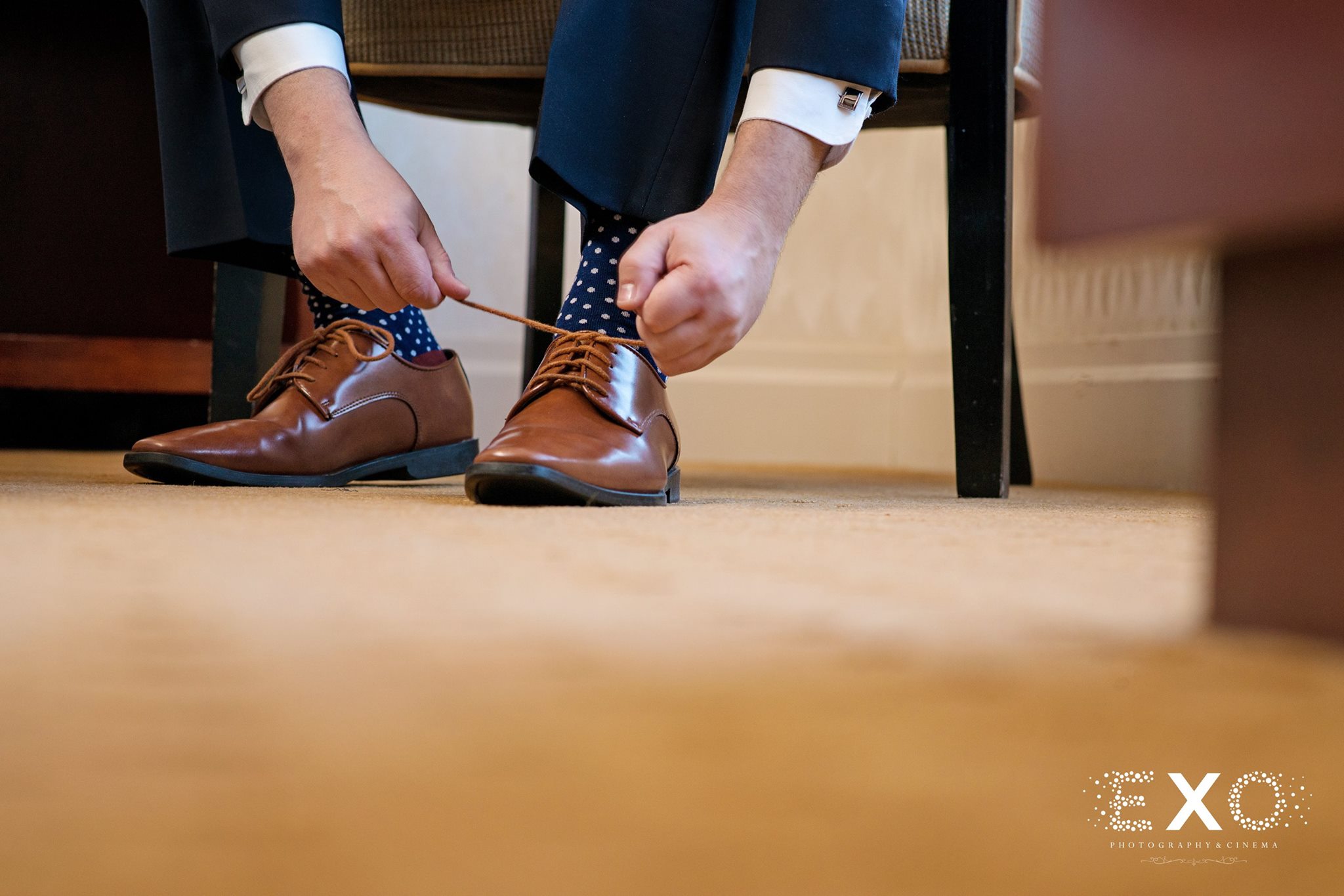 groom tying shoes before Soundview Caterers wedding ceremony