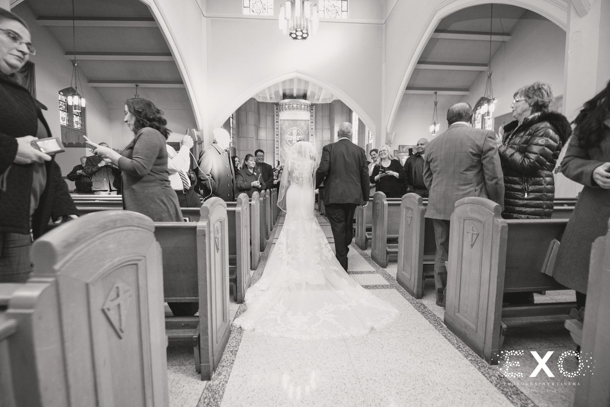 black and white photo of bride walking down aisle at long island wedding