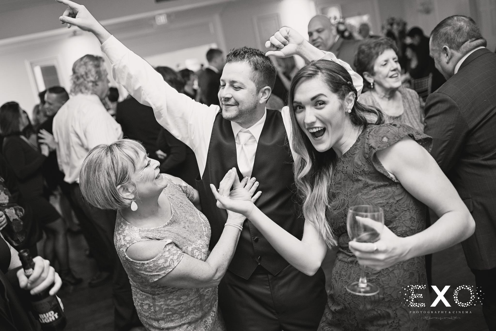 black and white photo of couple and wedding guests at reception