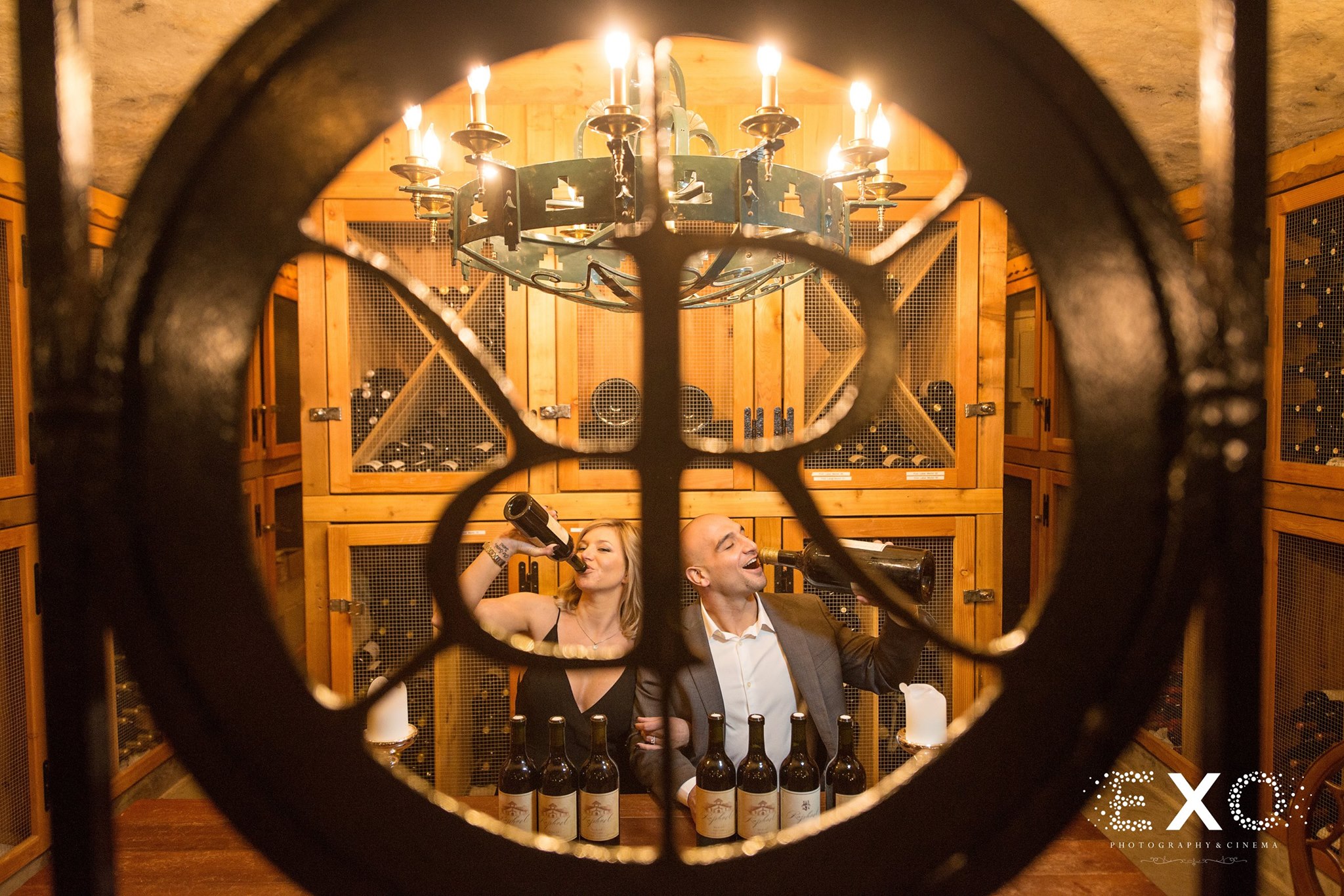 fun image of couple pretending to drink wine in cellar of Raphael Vineyard