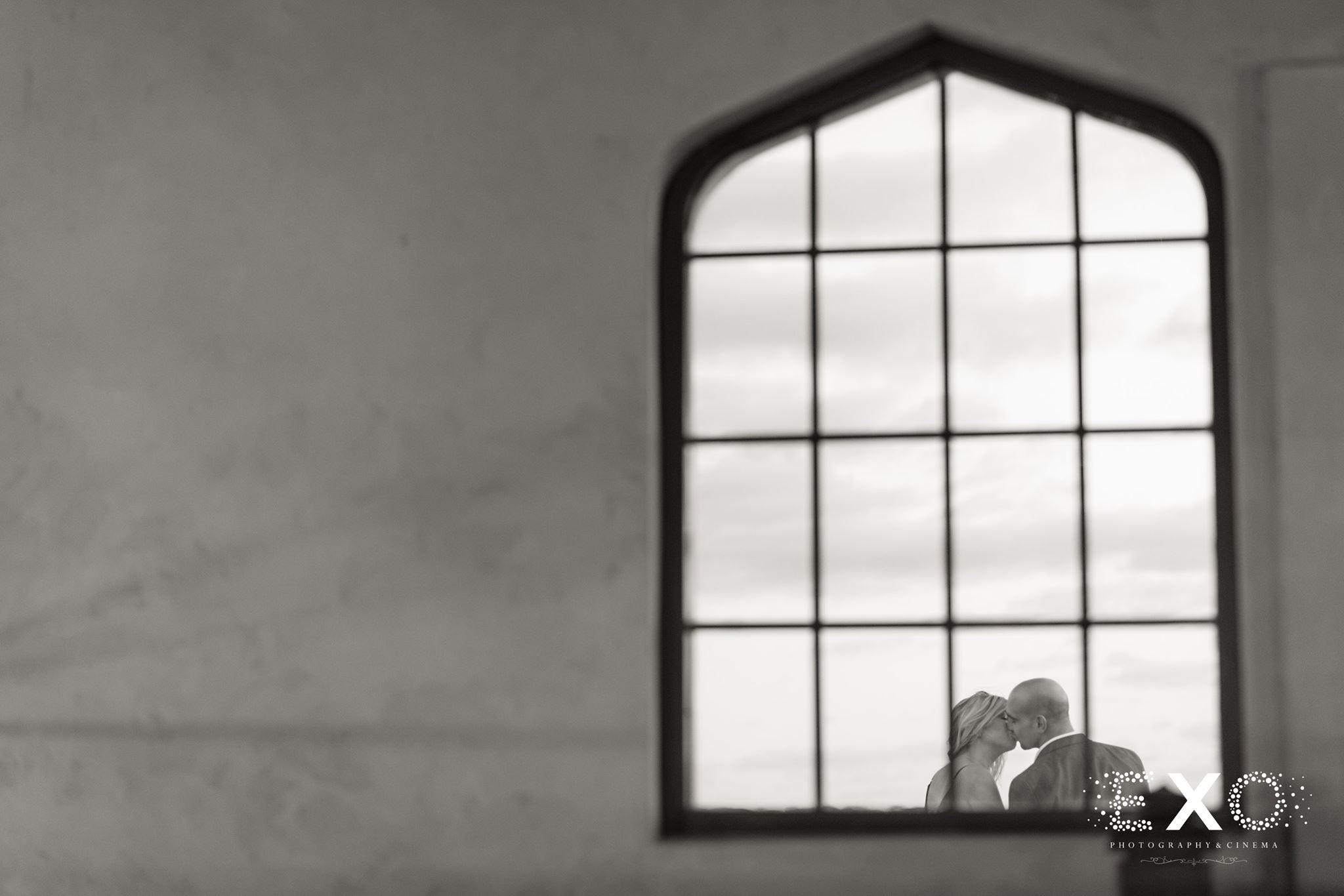 black and white image of couple through window at Raphael Vineyard engagement session