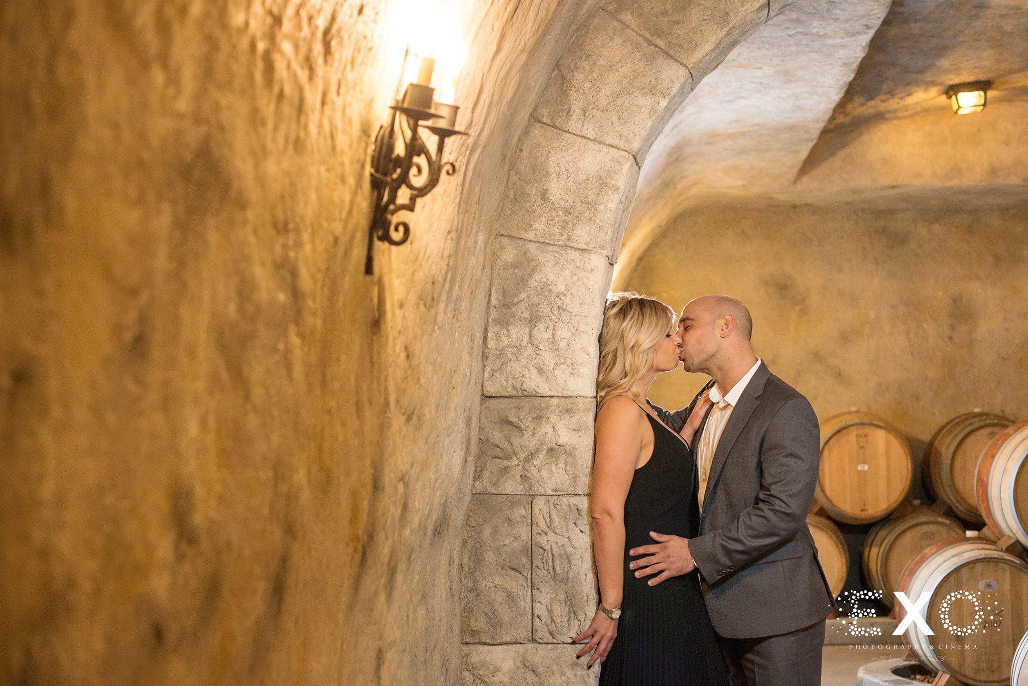 couple kissing near the stone wall at Raphael Vineyard engagement session