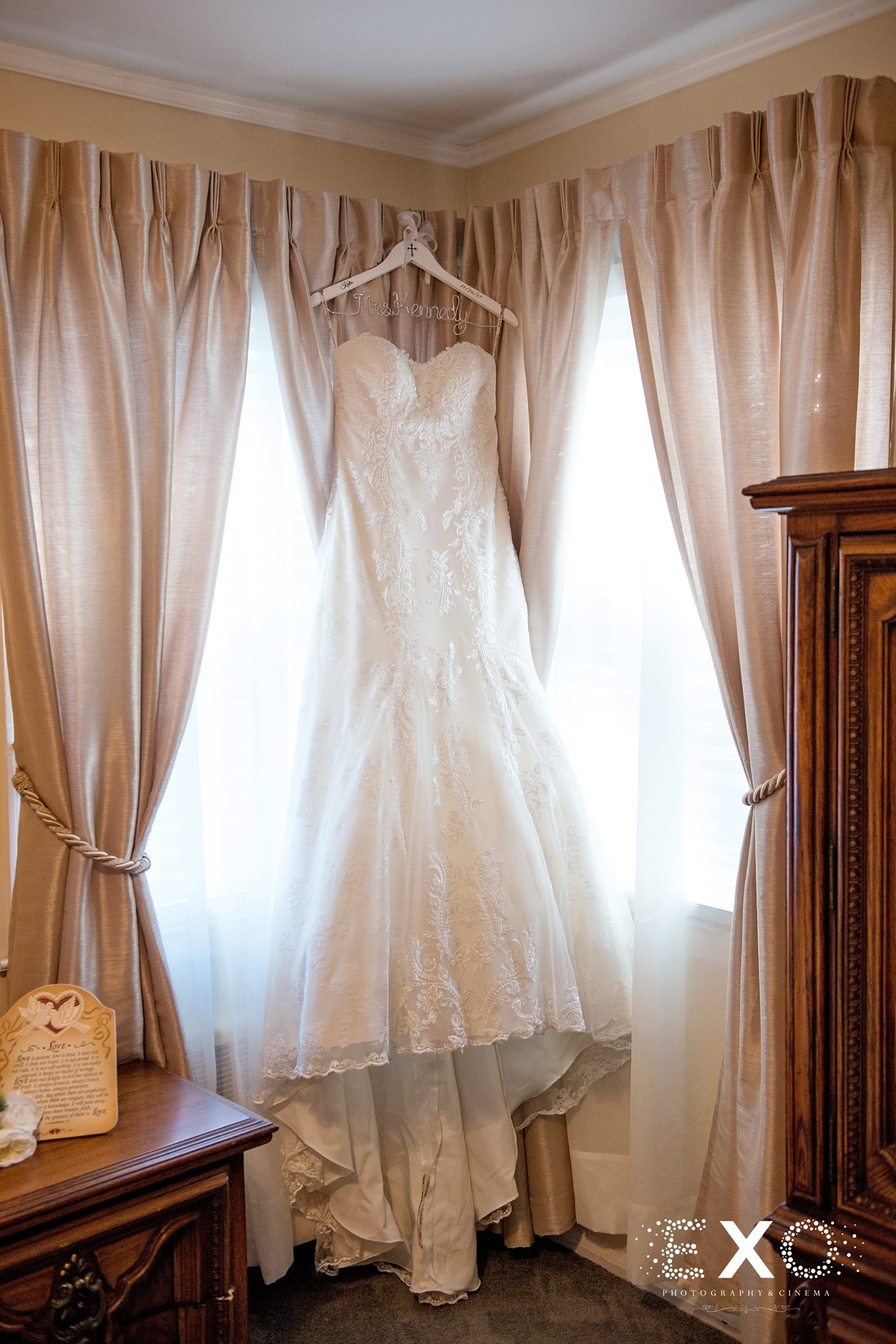 blossom bridal gown designed by maggie sottero hanging in window before long island wedding ceremony