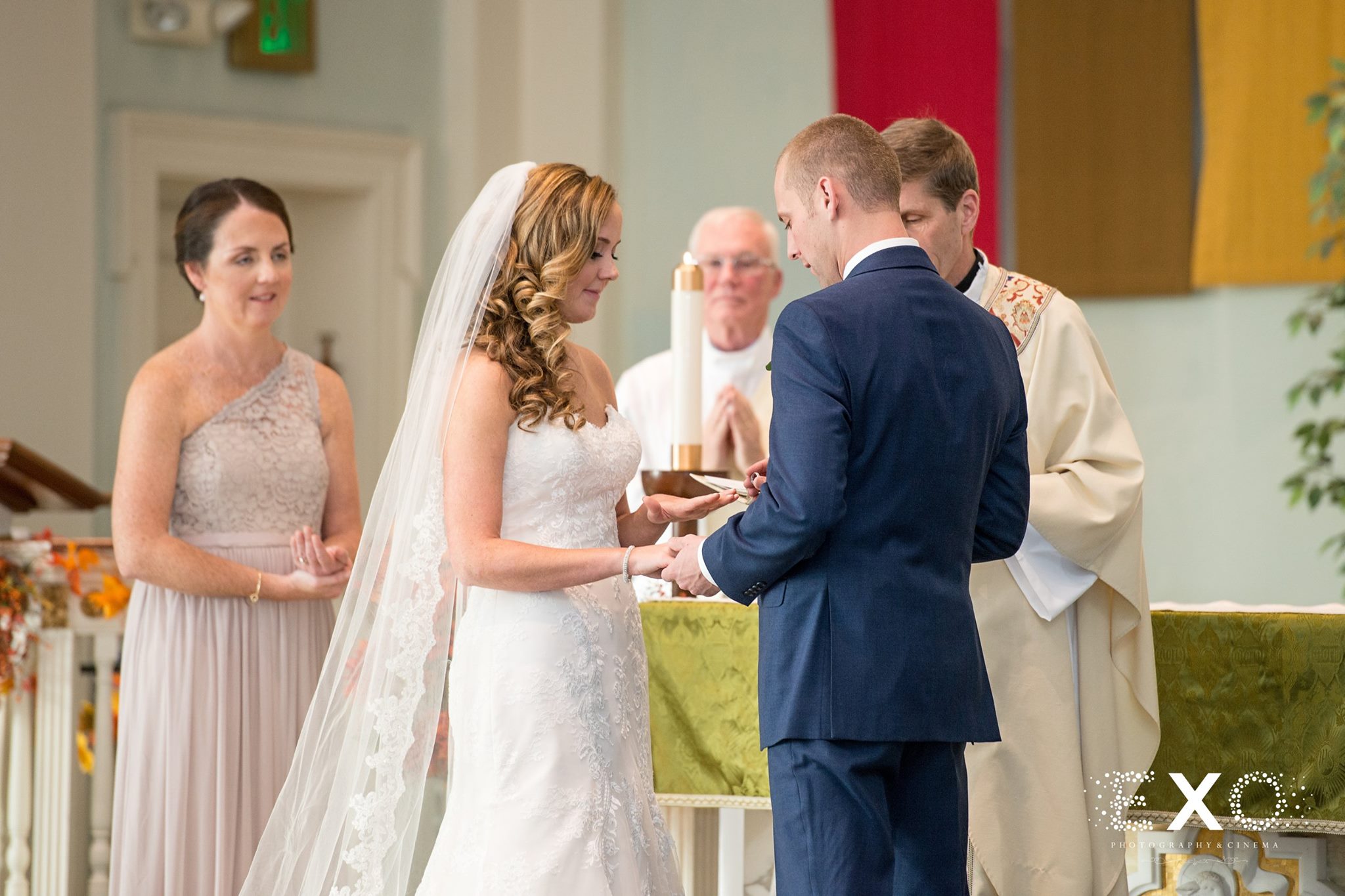 bride and groom exchanging rings and vows during long island wedding ceremony
