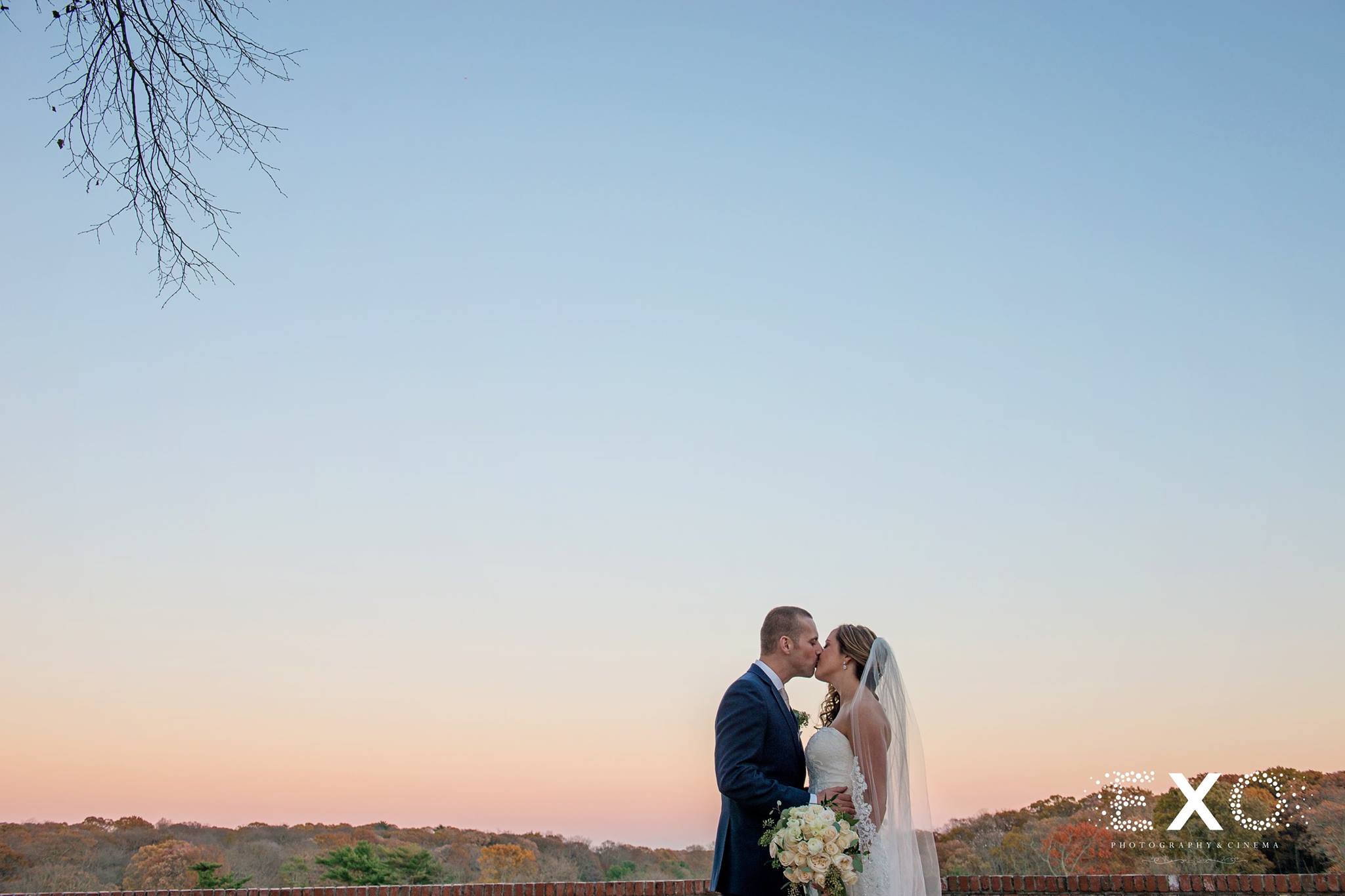 sunset image of couple kissing outside Heritage Club at Bethpage wedding near Long Island