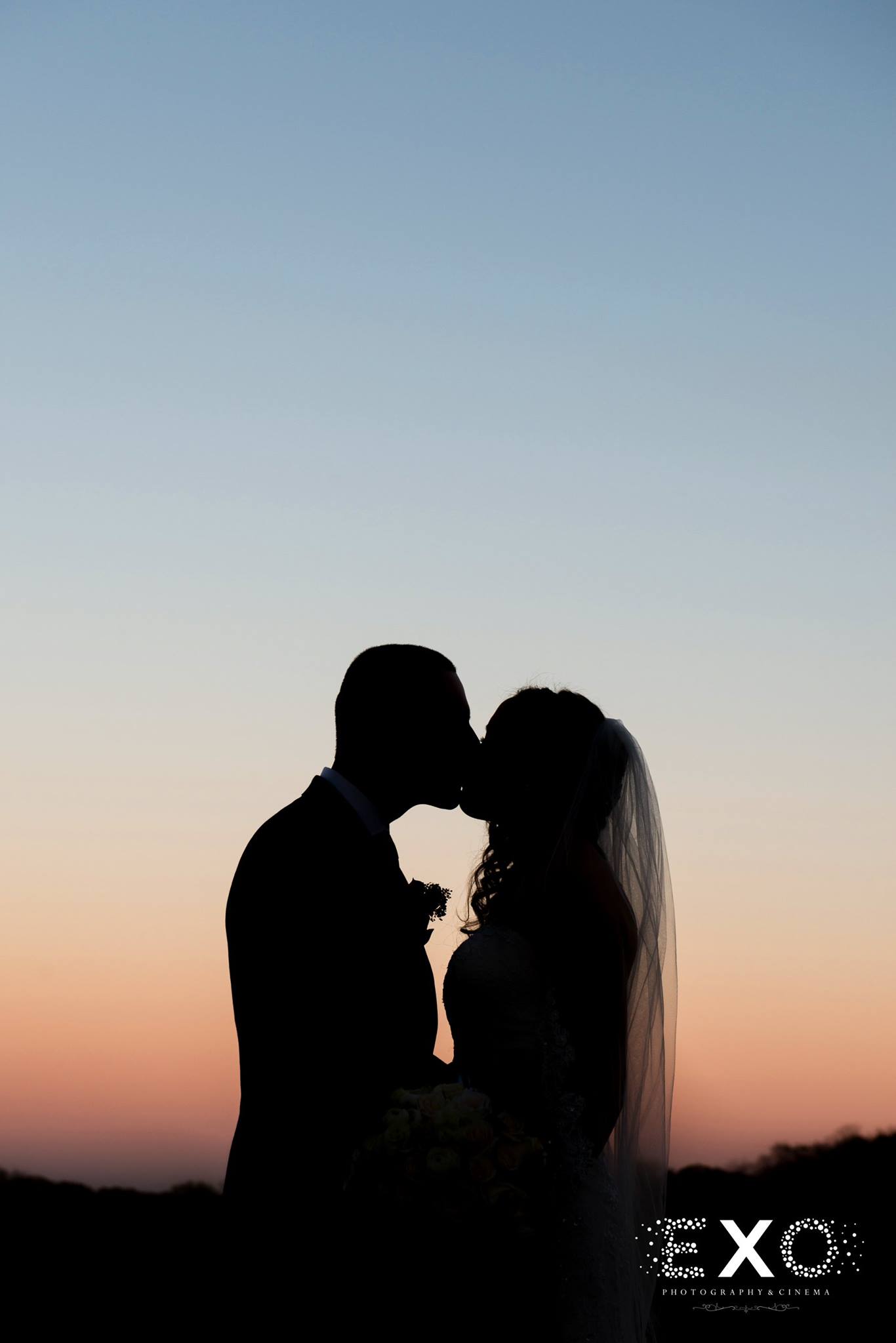 sunset silhouette shot of couple kissing outside Heritage Club at Bethpage wedding