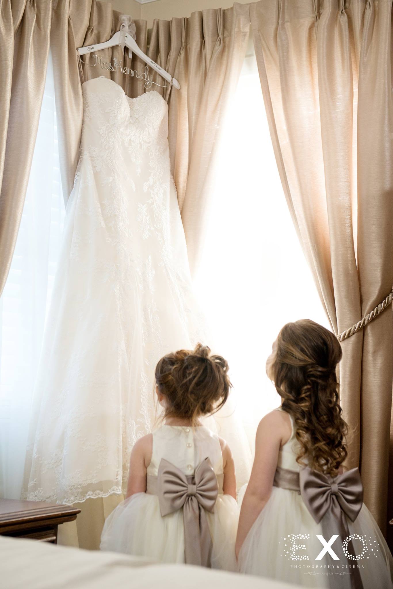 flower girls looking at bridal gown in window