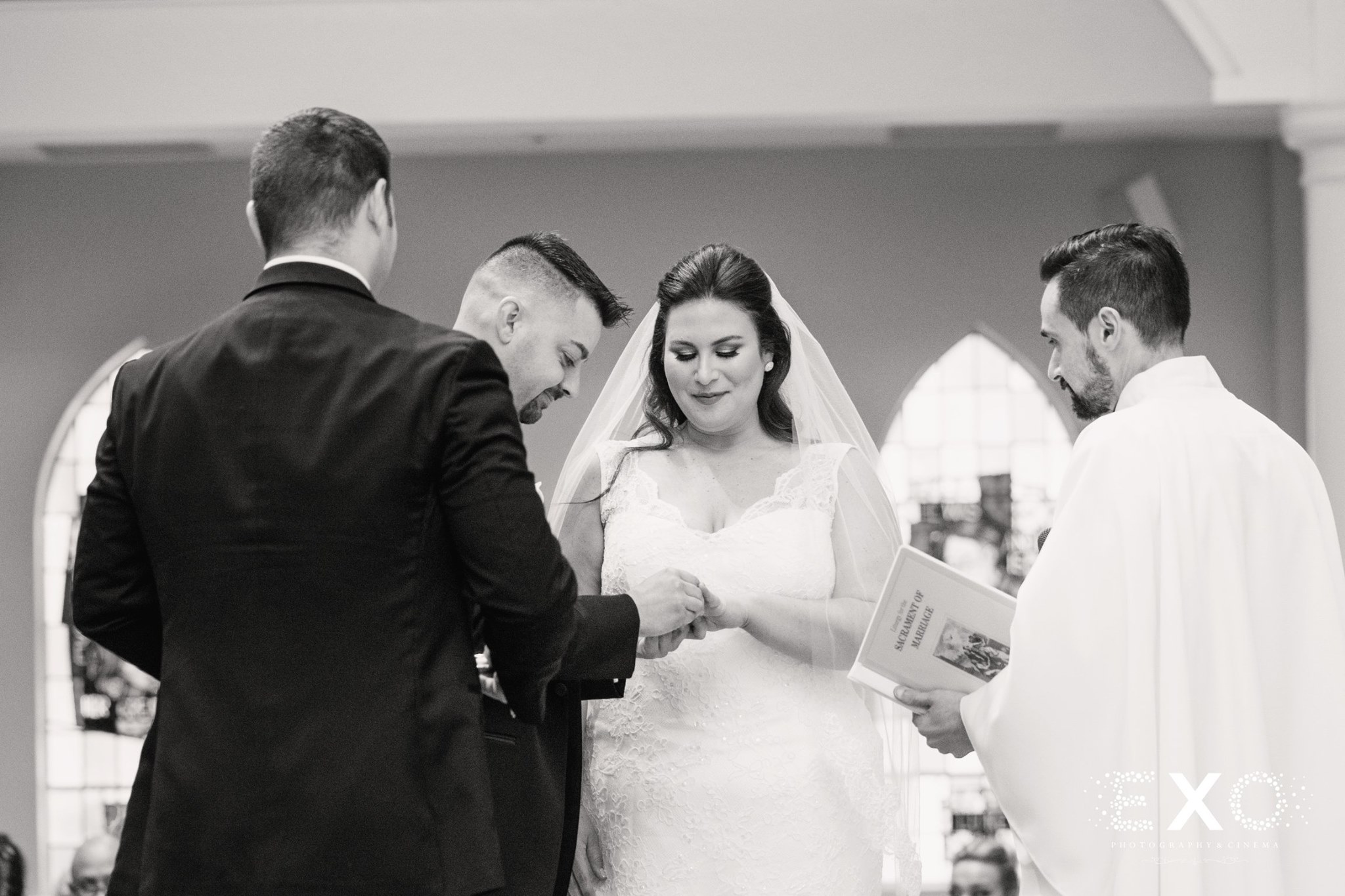 black and white image of couple exchanging rings by Zareen