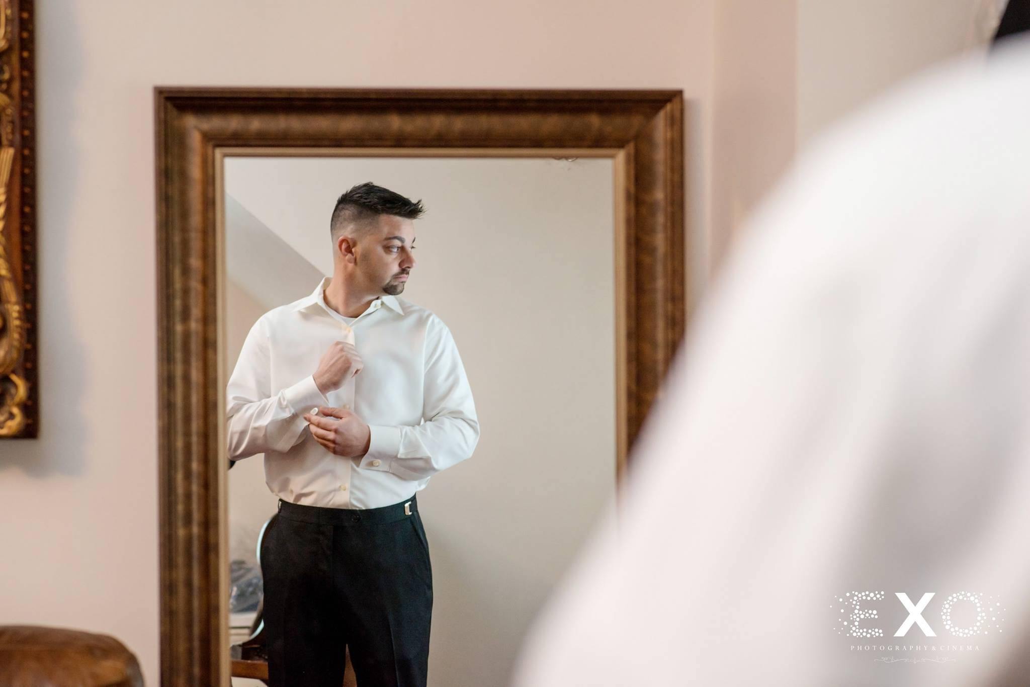 mirrored shot of groom getting ready for Royalton at Roslyn mansion wedding