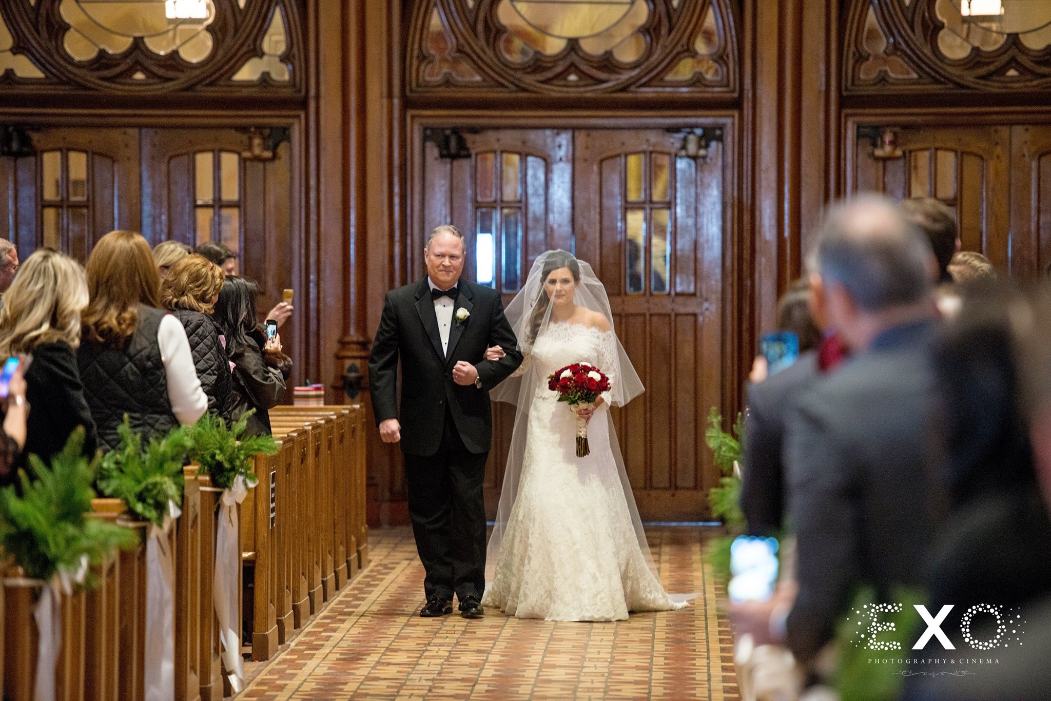 bride in Kleinfeld Bridal gown walking down aisle of church ceremony