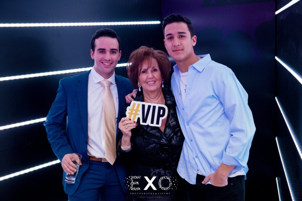 Grandma with guests holding #VIP sign in photo booth at The Piermont