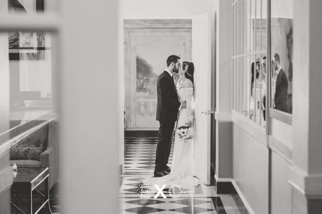 Bride and groom kissing in doorway at The Mansion at Oyster Bay