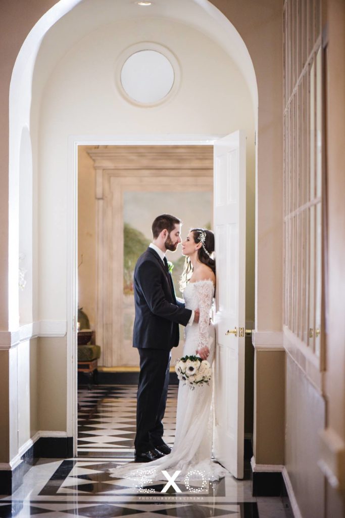Bride and groom in doorway looking at one another at The Mansion at Oyster Bay