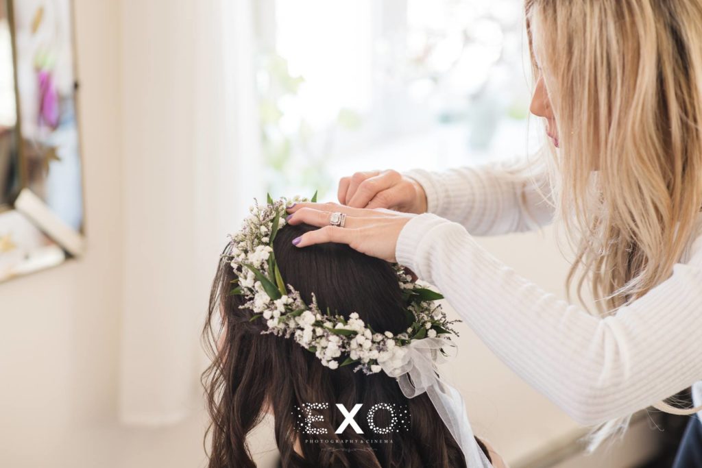Flower girl getting hair done from behind at The Mansion at Oyster Bay