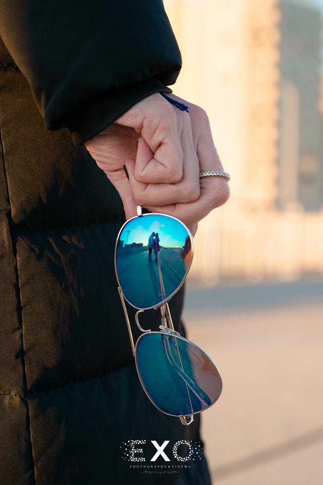 Couple kissing in sunglass reflection at Rockaway Beach