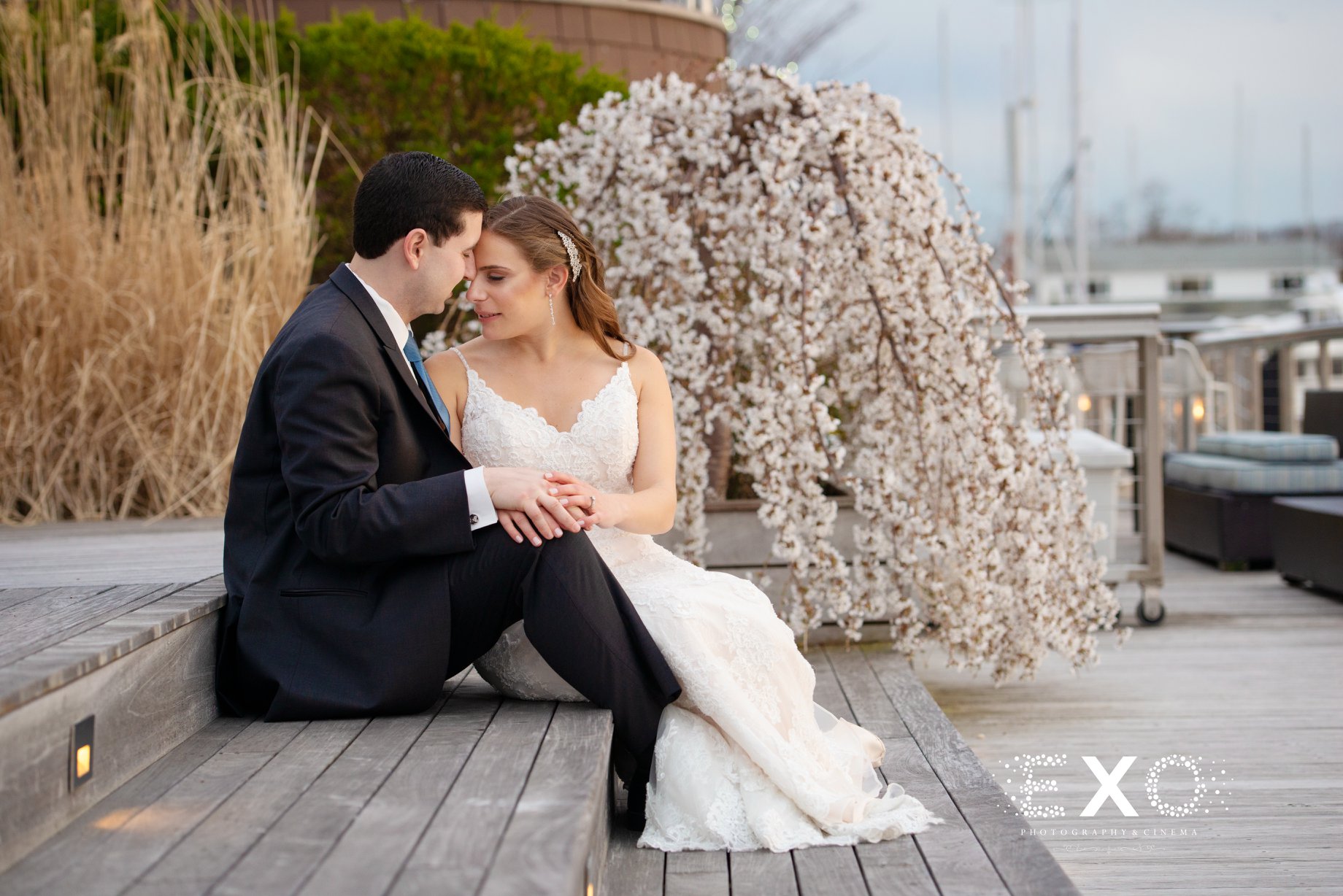 bride and groom sitting on the steps of the Harbor Club in Huntington