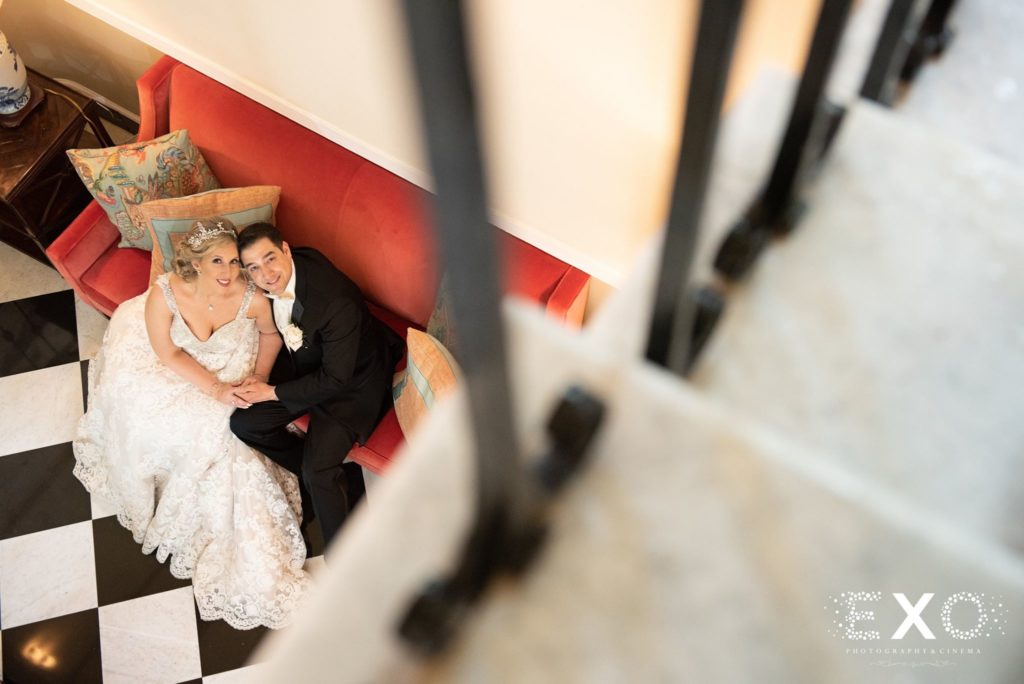 bride and groom posing on couch at The Mansion at Oyster Bay