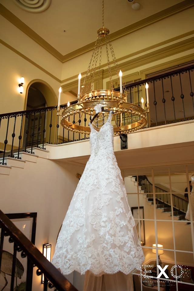 bride's gown hanging on lighting fixture at The Mansion at Oyster Bay