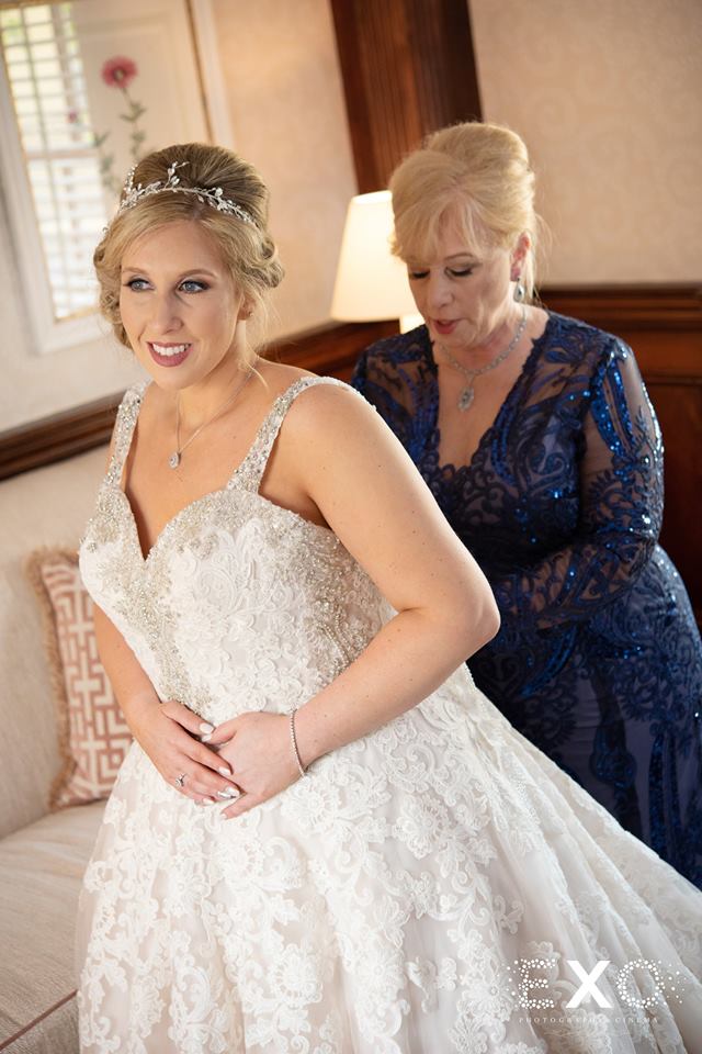 mother of bride helping zip up her dress at The Mansion at Oyster Bay