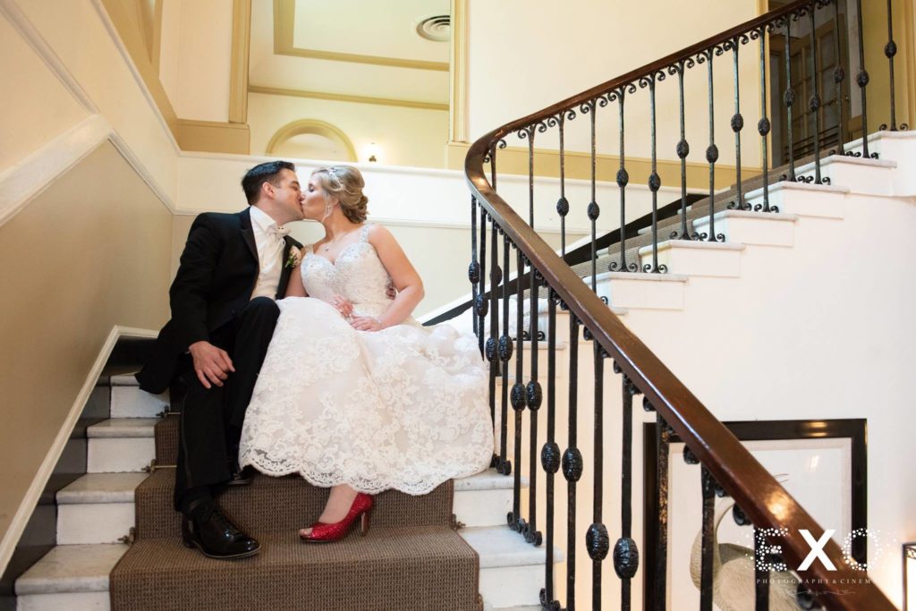 bride and groom kissing on steps at The Mansion at Oyster Bay