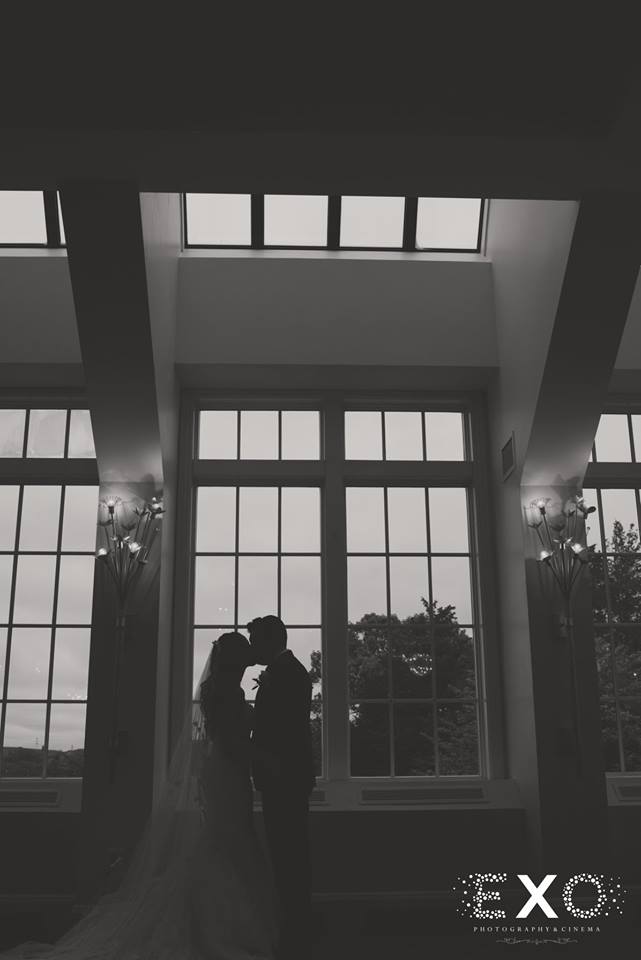 bride and groom kissing in the window at Heritage Club at Bethpage