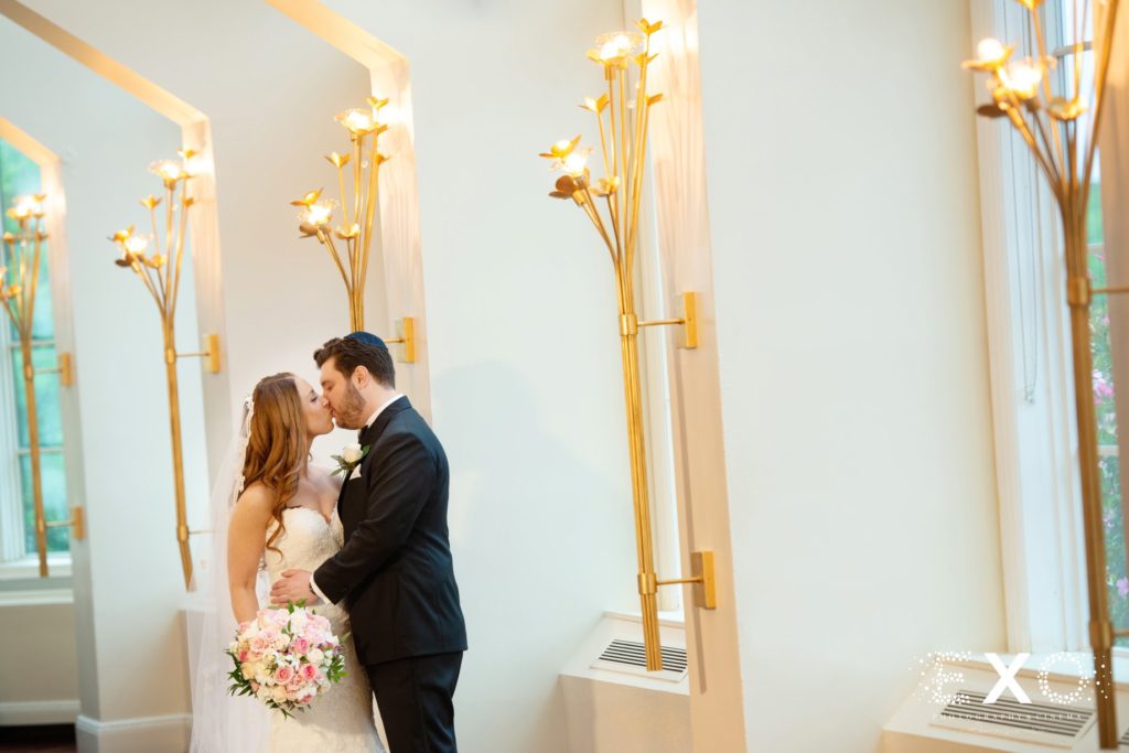 bride and groom kissing in the hallway at Heritage Club at Bethpage