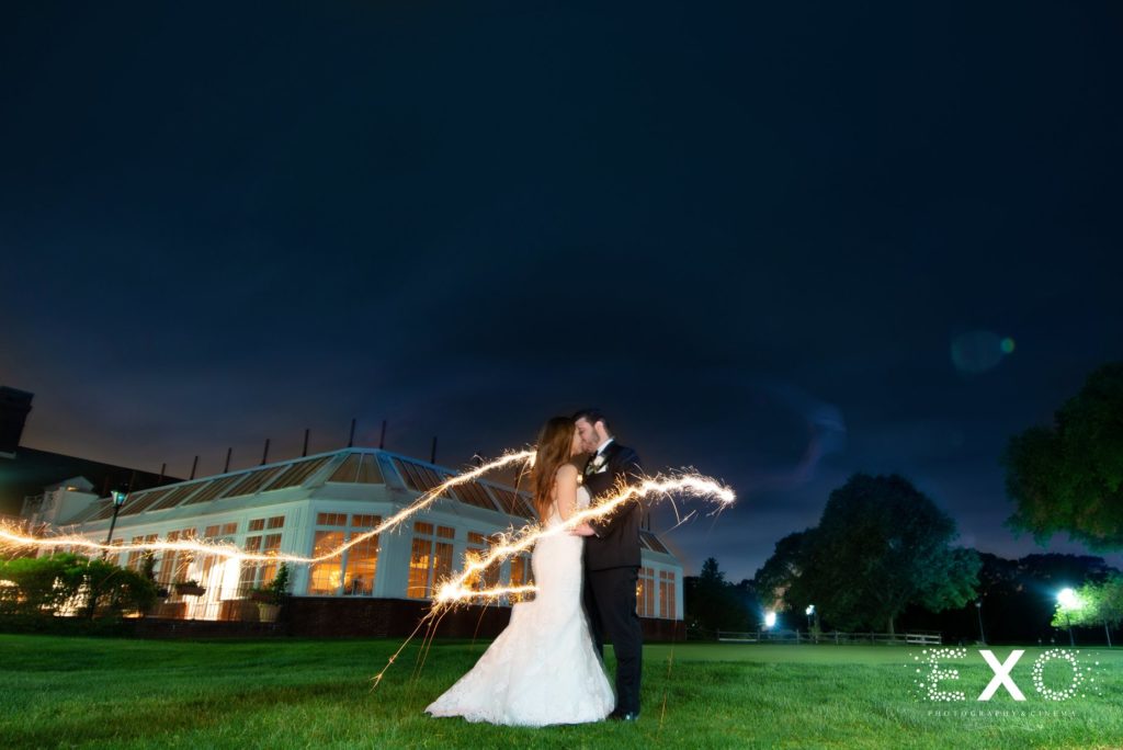 bride and groom kissing outside Heritage Club at Bethpage with lights