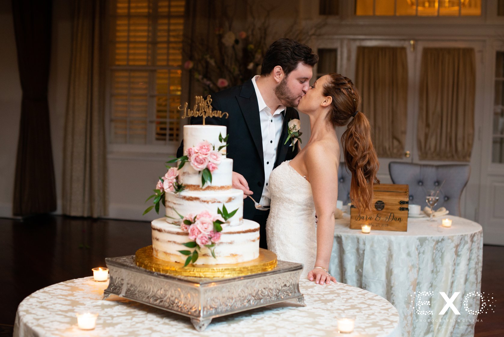 bride and groom kissing in front of the cake at Heritage Club at Bethpage
