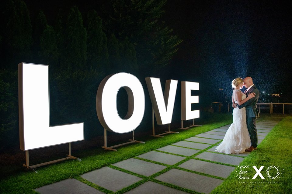 bride and groom with LOVE sign at Harbor Club at Prime