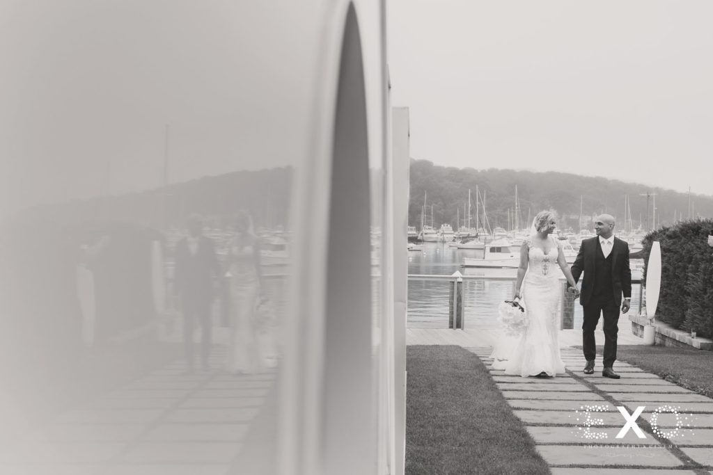 bride and groom walking away from the water