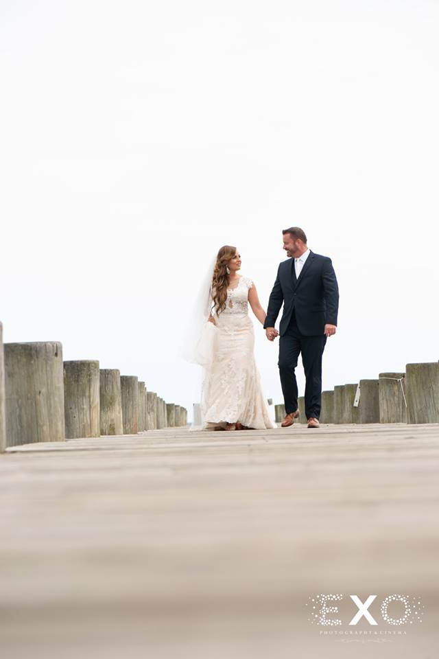 bride and groom walking along the dock at Lombardi's on the Bay
