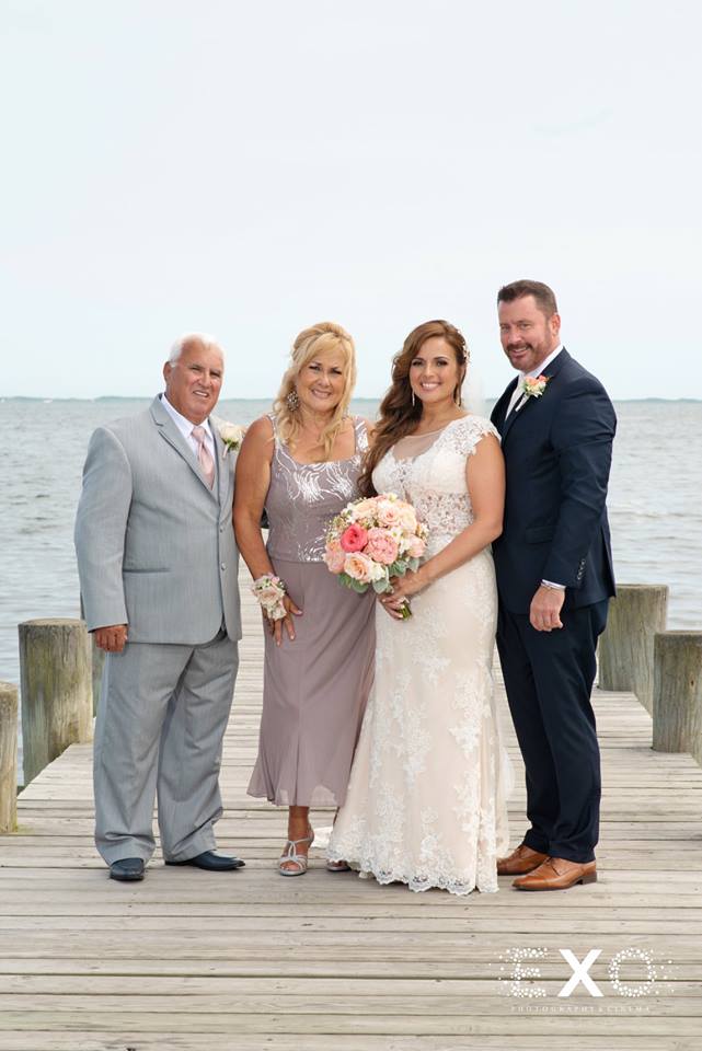 bride and groom with parents on dock