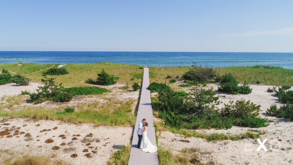 bride and groom kissing on boardwalk, drove view