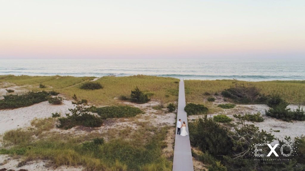 drone view of bride and groom on boardwalk at Oceanbleu