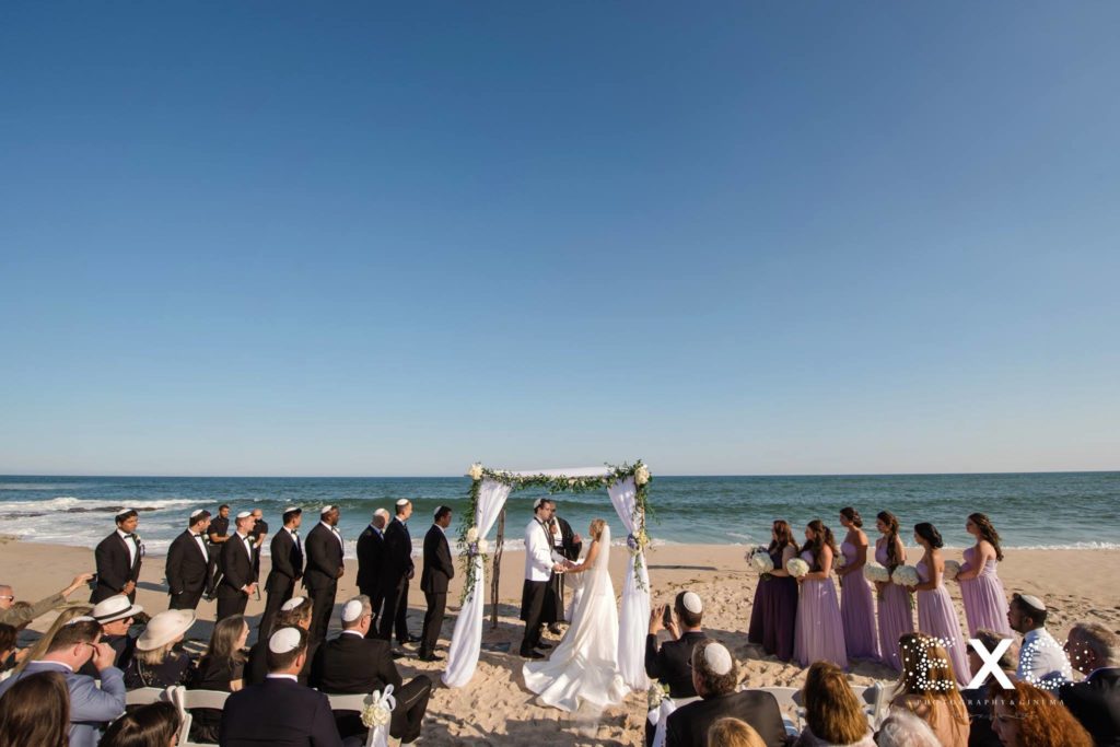 bride and groom exchanging vows under the chuppah at Oceanbleu