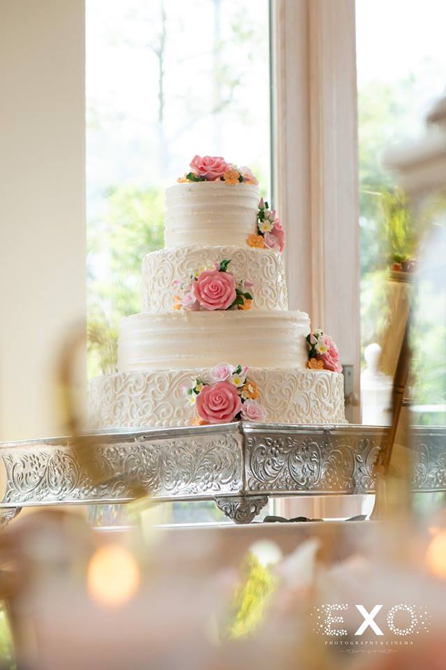 White wedding cake with pink flowers at Fox Hollow